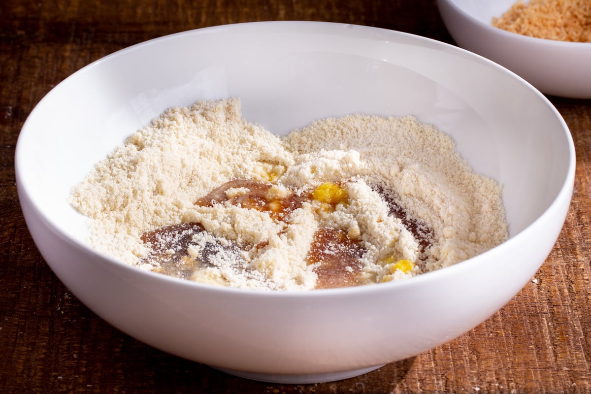 maple syrup and lemon zest being added to a bowl