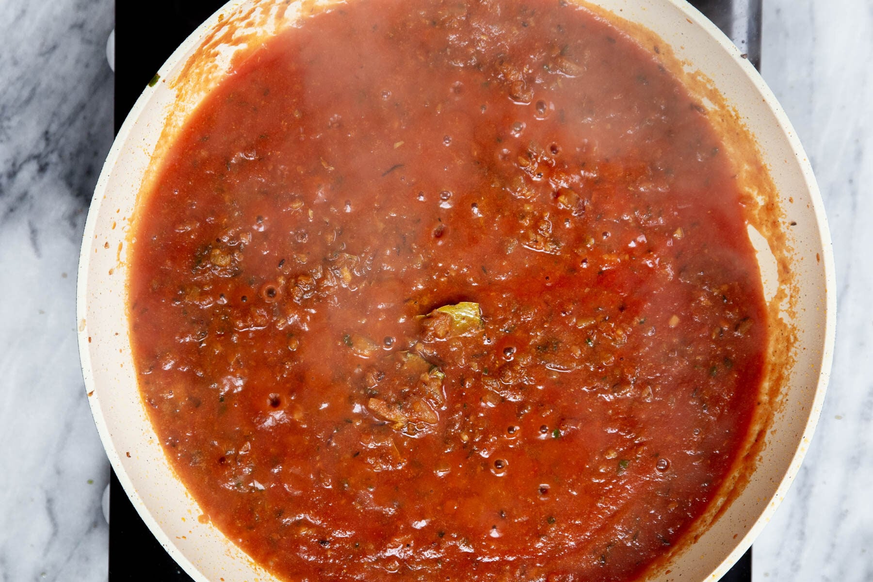 spiced tomato sauce simmering in a pan