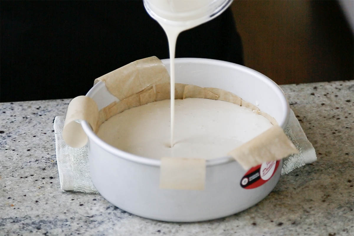 pouring cheesecake mixture into the pan