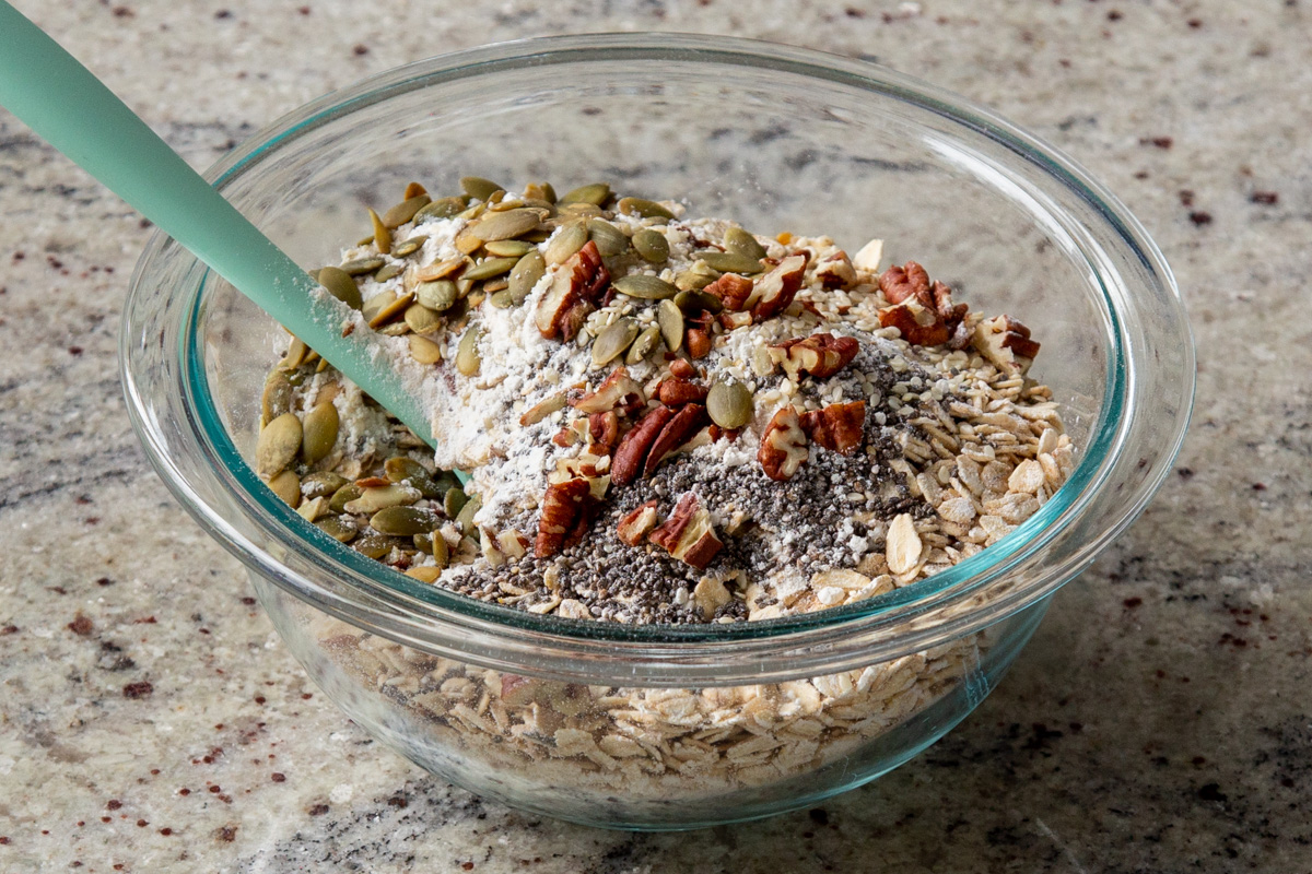 adding more nuts and seeds to the dry oats mixture