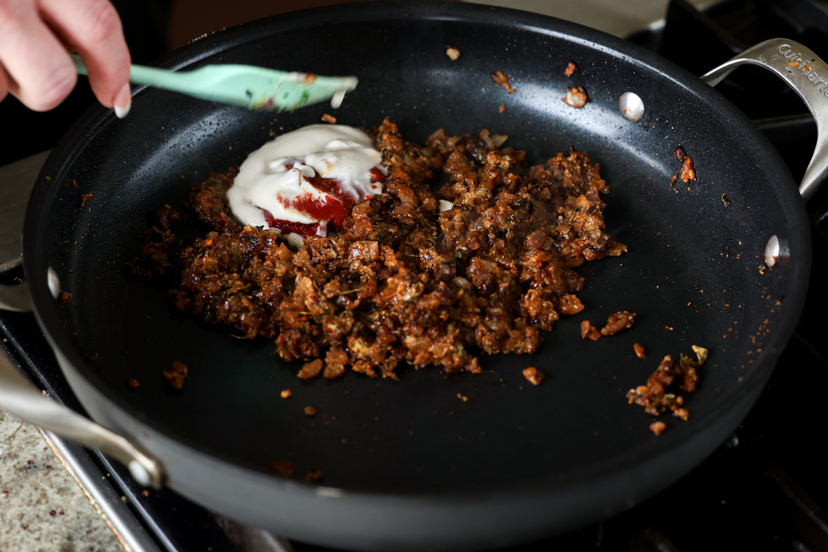 adding tomato paste and non-dairy yogurt to the pan