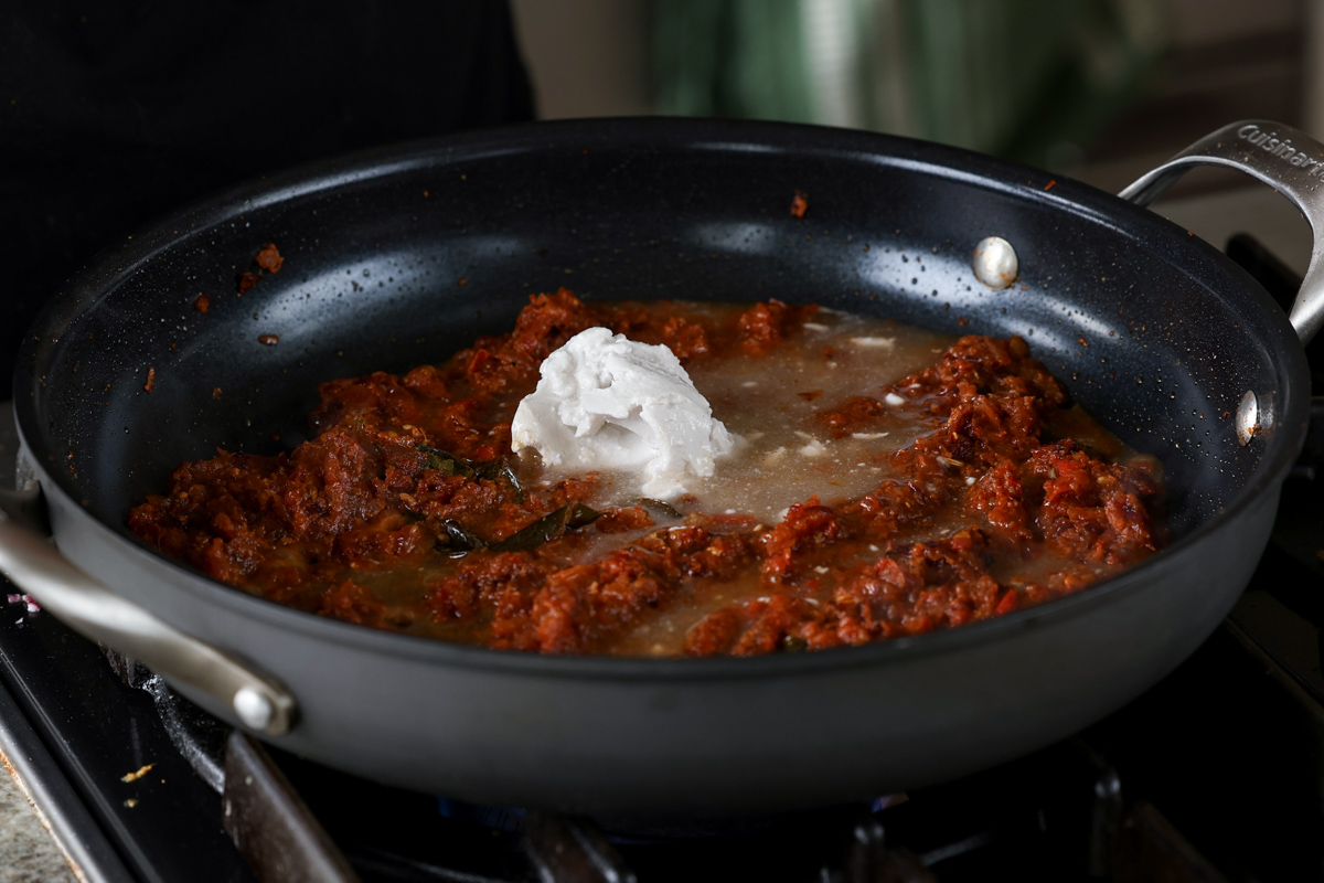 adding coconut milk to the pan