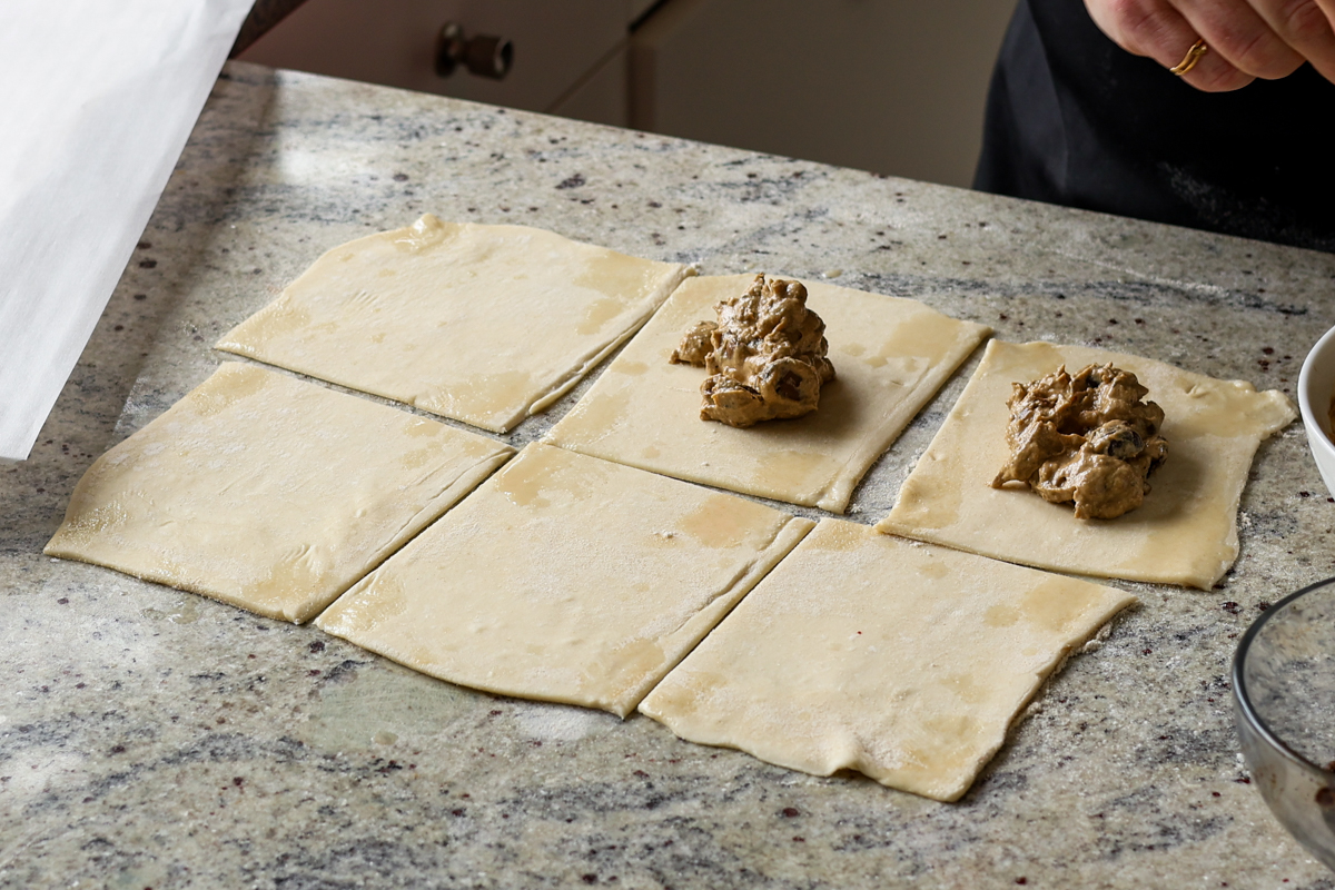 adding creamy mushrooms to the puff pastry