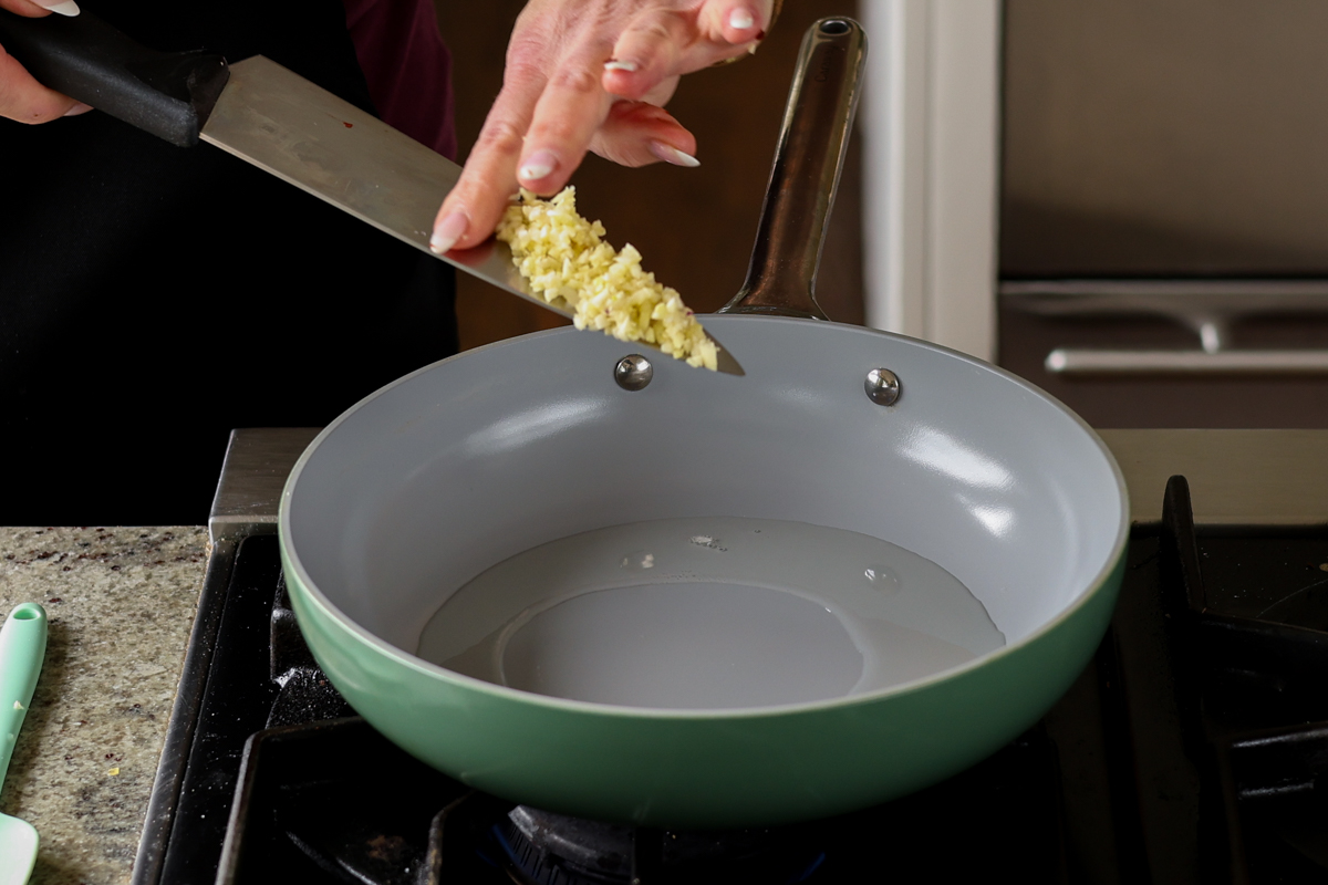 adding garlic to the pan