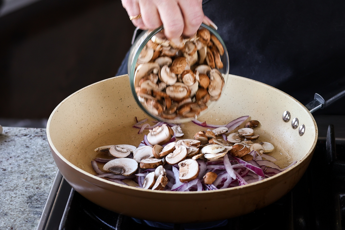 adding mushrooms to the pan