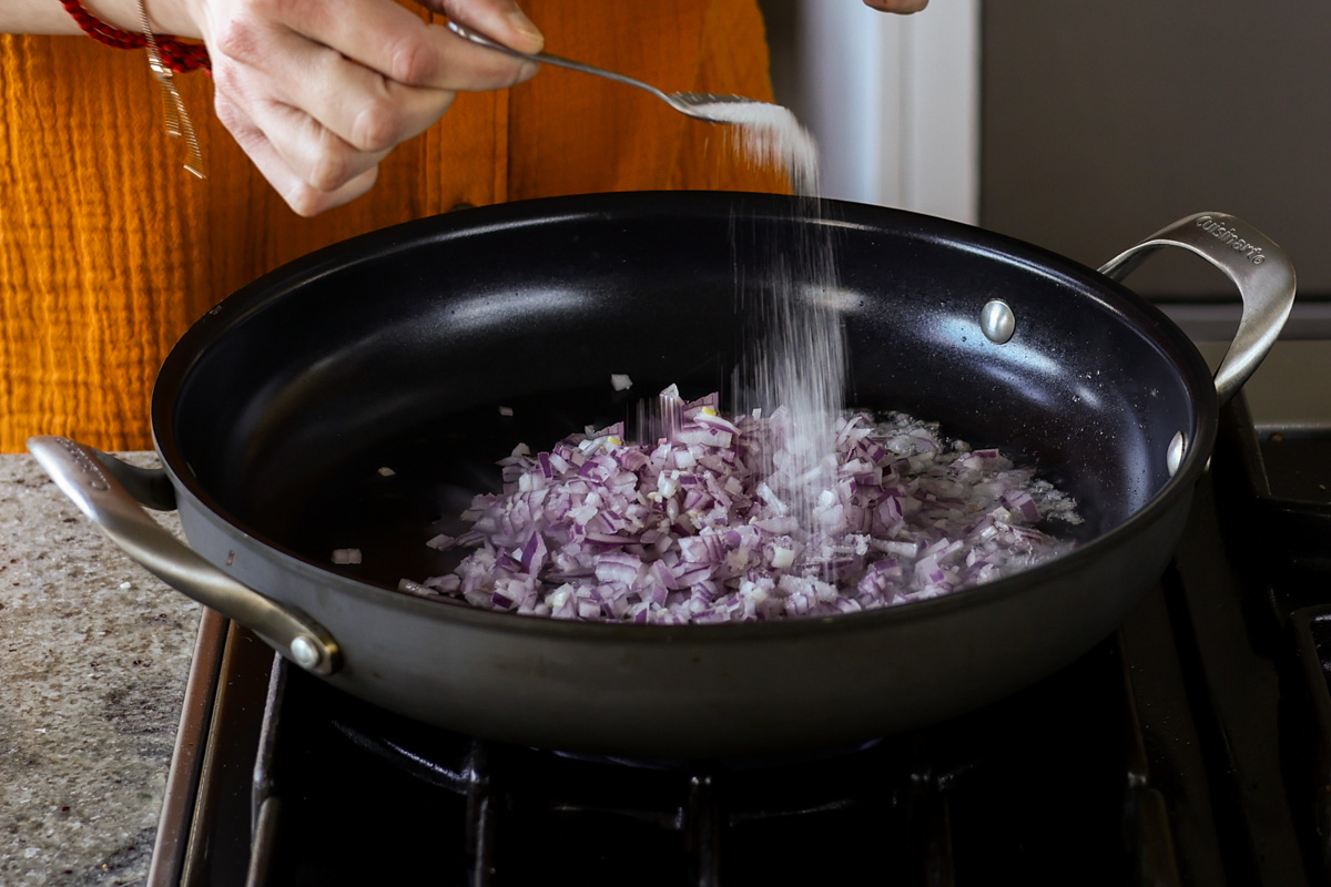 adding onion and salt to the pan
