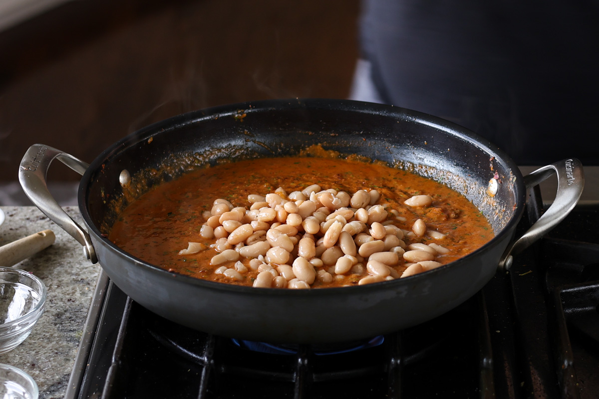 adding beans to the korma sauce