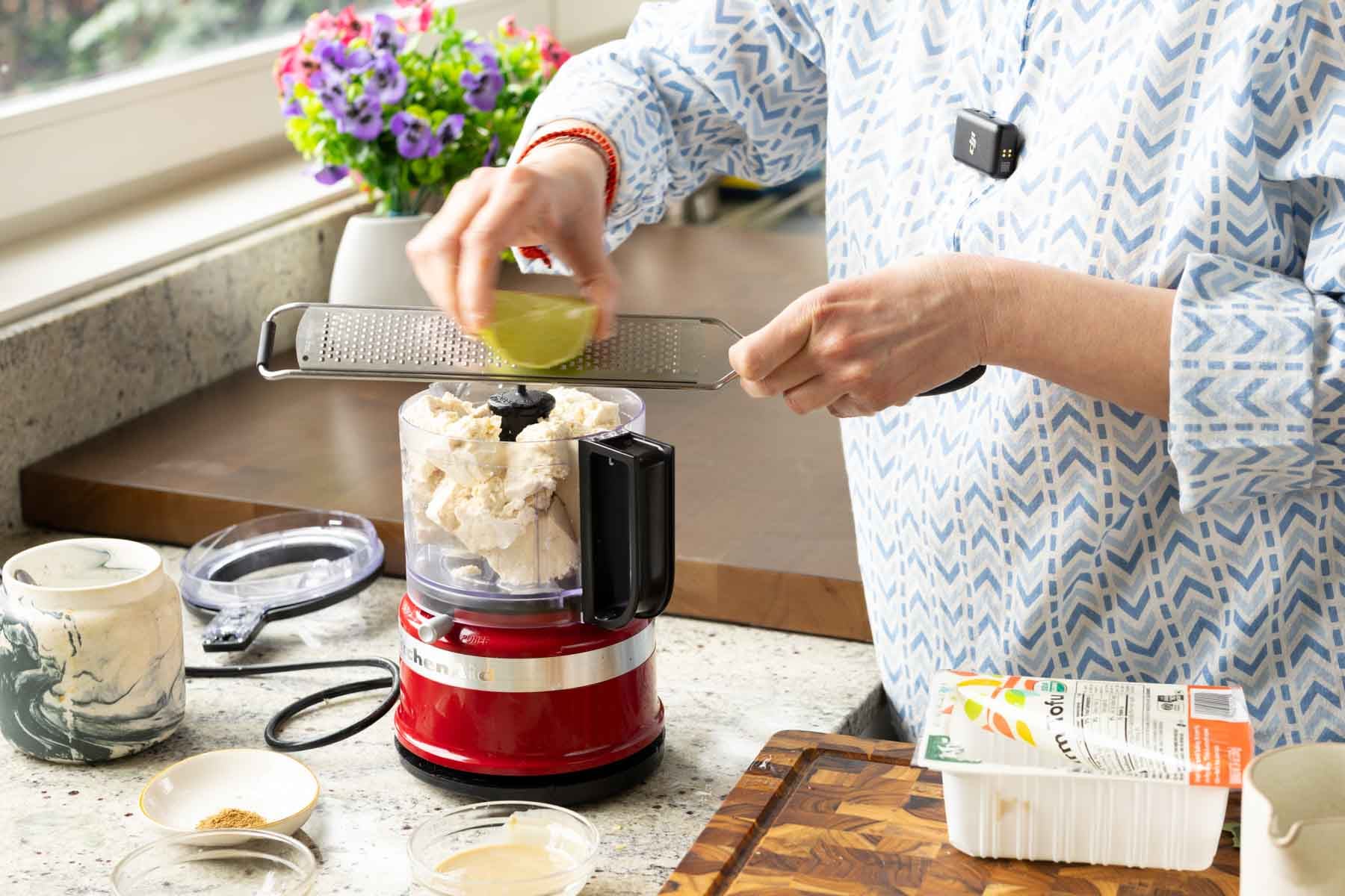 adding whipped tofu ingredients to the food processor