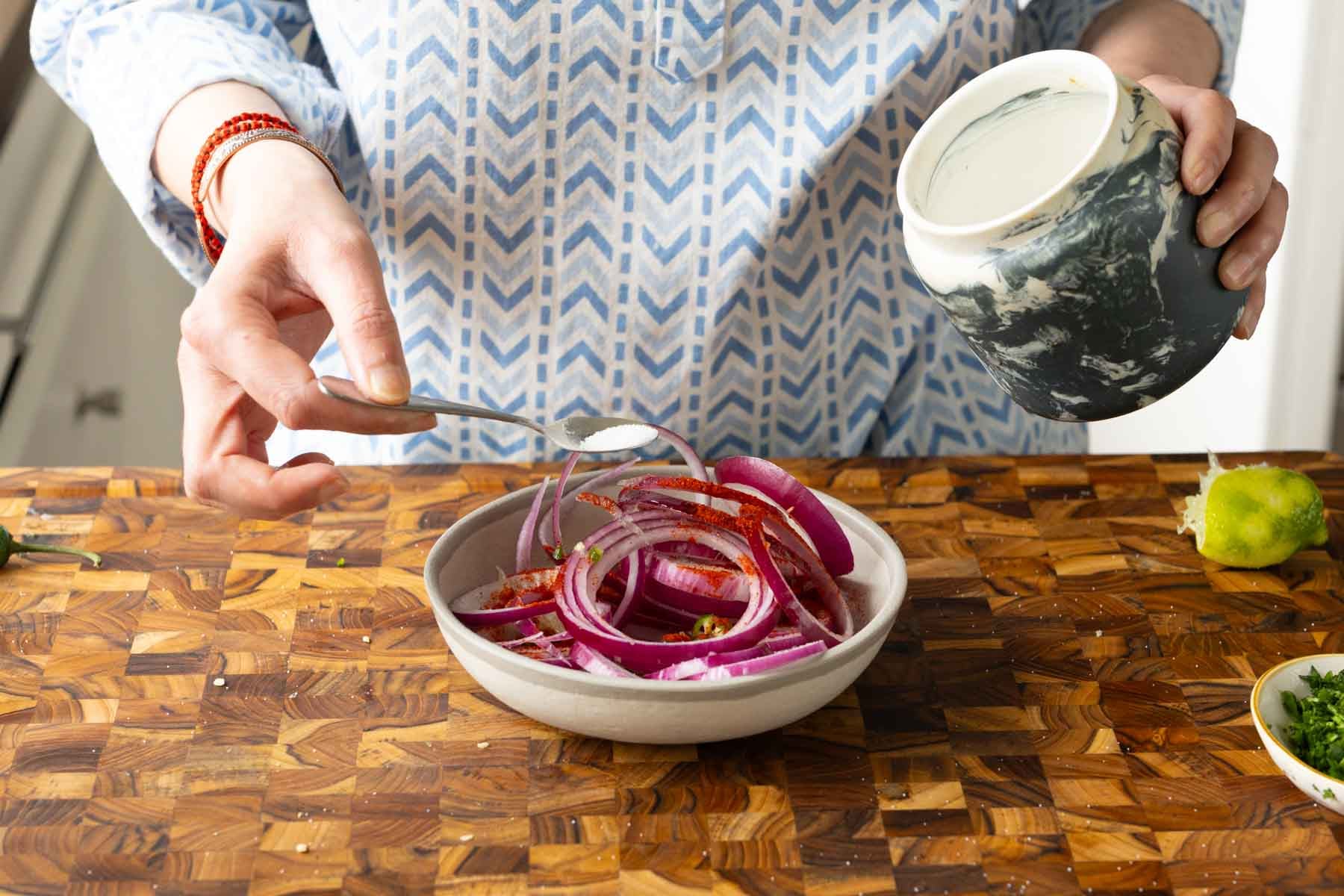 adding onion salad ingredients to a bowl