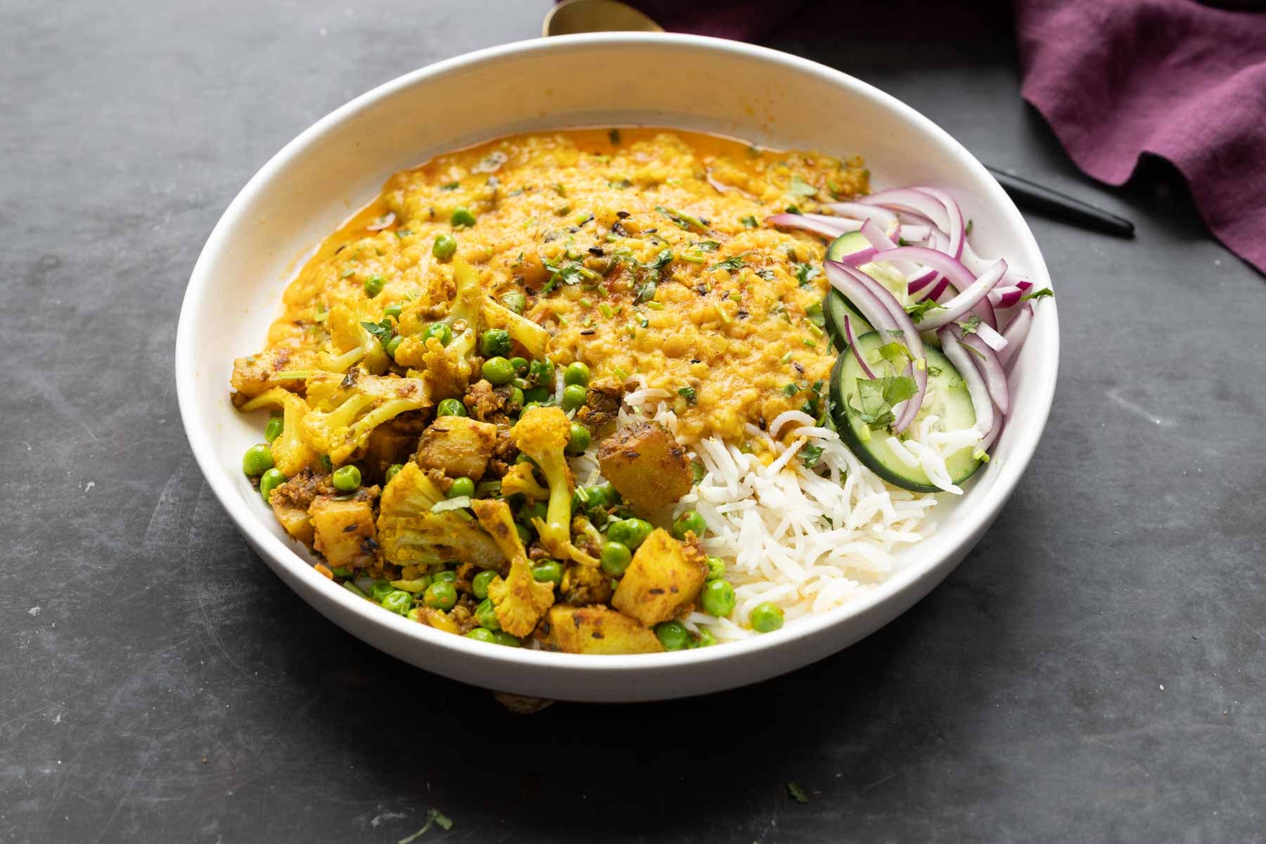 plate of jeera dal with a side of cauliflower and potatoes